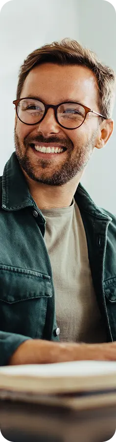 Smiling man with glasses wearing a green jacket